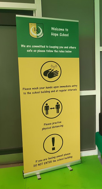 Banner stand for a Primary School displaying Coronavirus Covid 19 social distancing and hygiene message