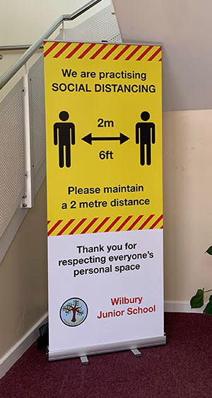 Banner stand for a Primary School displaying Coronavirus Covid 19 social distancing message