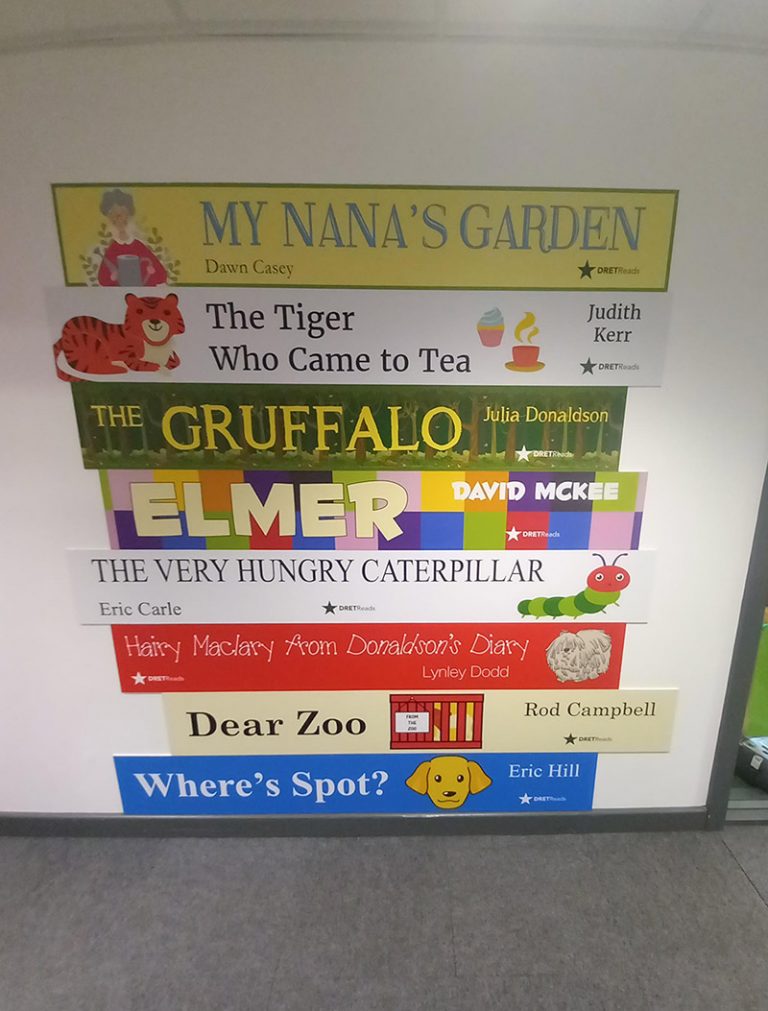 Book spine graphics on a wall at a Primary School