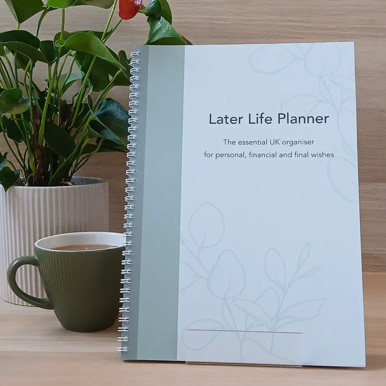 The front cover of the Later Life Planner book, an essential UK organiser, displayed on a desk with a coffee mug and greenery.