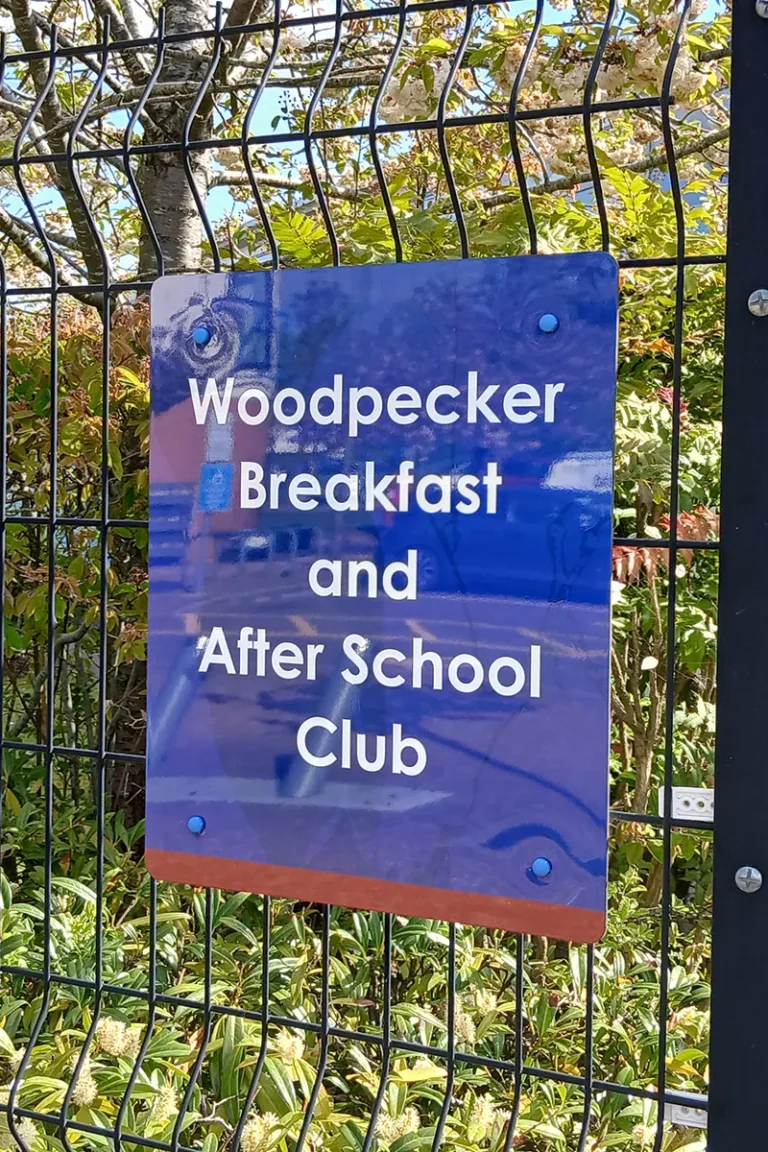 breakfast-club-wayfinding-sign-howe-park-school-milton-keynes Breakfast club and after school club wayfinding sign fitted on a fence at a school entrance - Howe Park School, Milton Keynes
