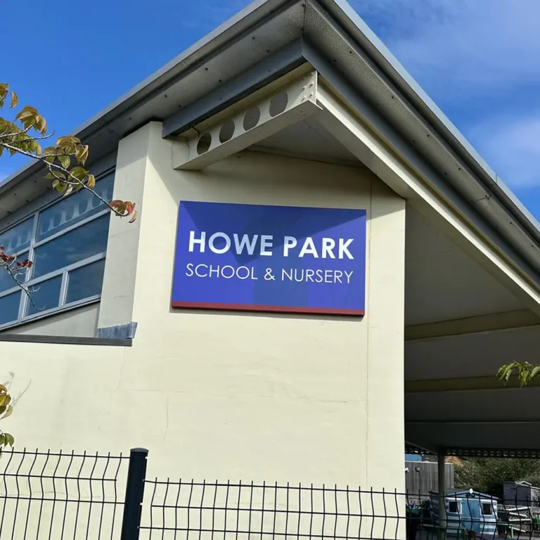 main-school-entrance-signage-howe-park-school-milton-keynes Main school entrance sign showing school name with the school woodpecker logo faded into the background - Howe Park School, Milton Keynes