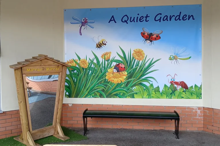 pvc-banner-howe-park-school-milton-keynes-1 A quiet garden PVC banner fitted to wall in the playground featuring plants and insects with a blue sky background - Howe Park School, Milton Keynes